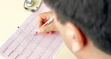 Врач анализирует кардиограмму Врач анализирует кардиограмму